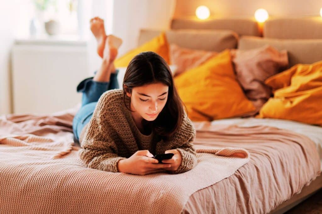Female teenager on the internet on her phone and potentially being exposed to teenage grooming