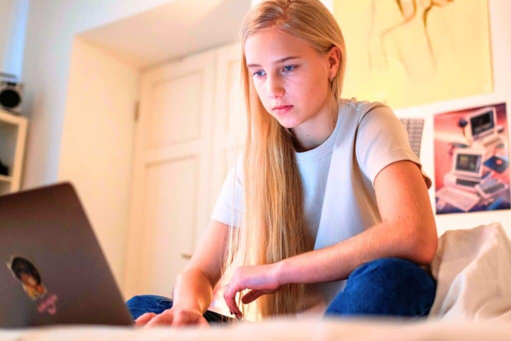 Teenager in bedroom on laptop