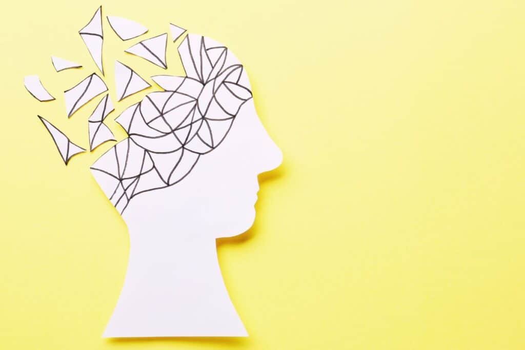 brain made of paper breaking up on yellow background