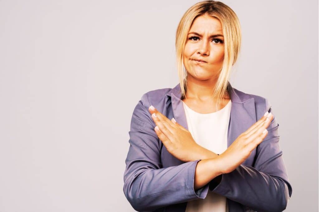 women with tied back blonde hair and a grey shirt with arms crossed indicating her challenging myths about sexual violence