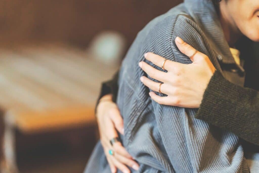 two women hugging not considering that some of the well-intentioned phrases used could contribute to victim blaming